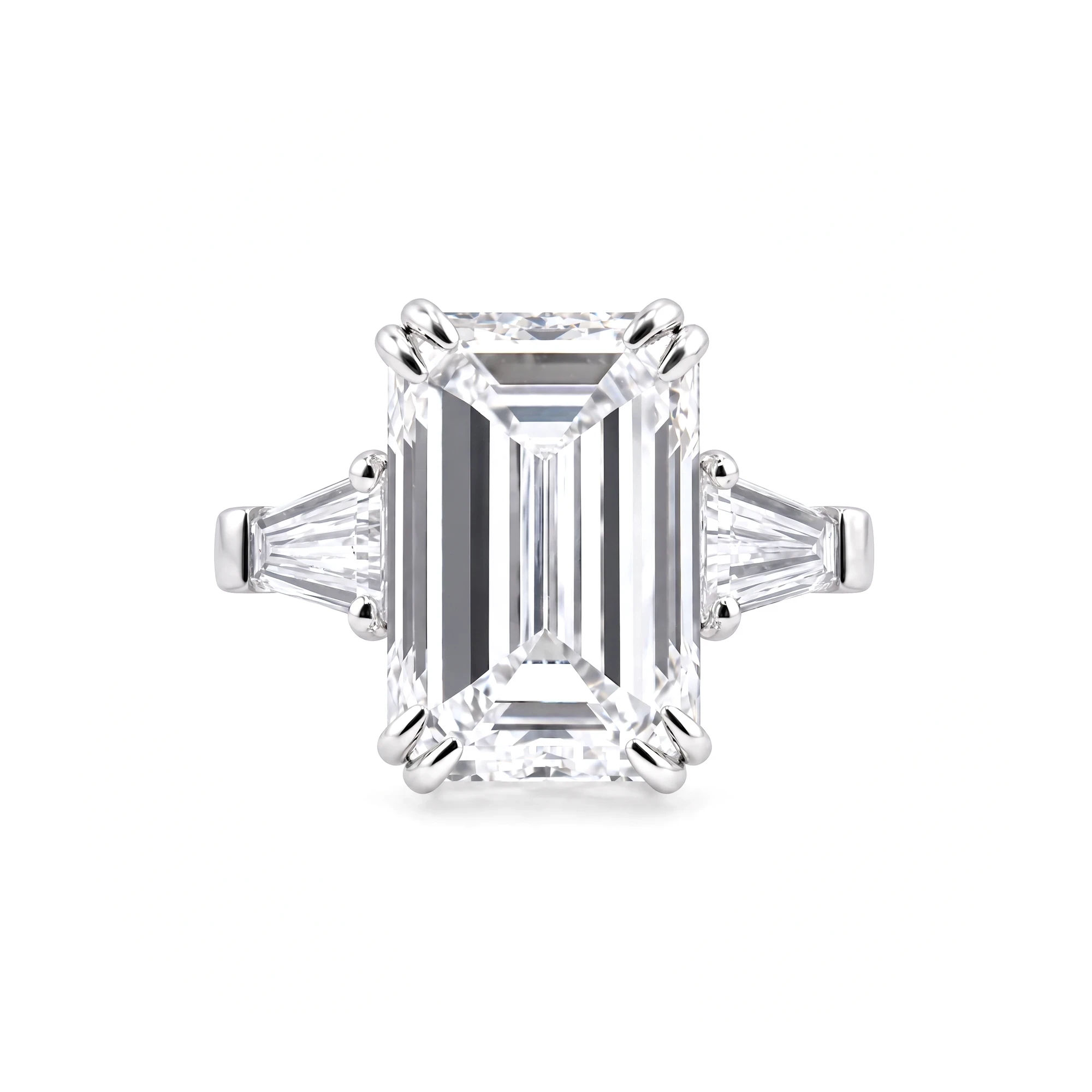 Packshot of an emerald-cut diamond ring with tapered baguettes, seen from above on pure white